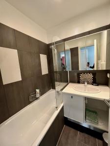 a bathroom with a tub and a sink and a bath tub at Splendid house, Jacuzzi and Private Gardens Paris in Boulogne-Billancourt