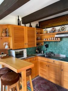 a kitchen with wooden cabinets and a wooden table at Family lake house Zbilje in Ljubljana