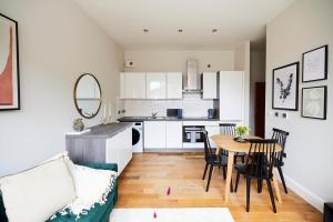 sala de estar y cocina con mesa y sillas en The Waltham Forest Escape - Adorable 2BDR Flat en Londres