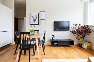 a dining room with a table and chairs and a tv at The Waltham Forest Escape - Adorable 2BDR Flat in London