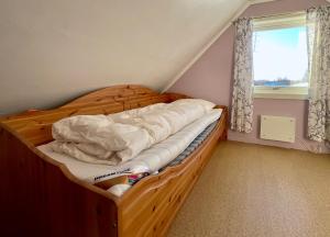a bed with a wooden frame in a room with a window at Fishermans Paradise Lofoten in Leknes