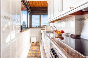 a kitchen with white cabinets and a bowl of fruit on the counter at La Nogalera - Sea view apartment in the heart of Torremolinos in Torremolinos