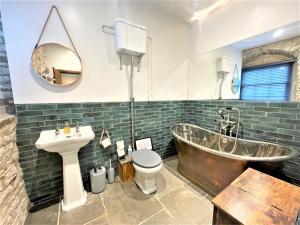 a bathroom with a tub and a toilet and a sink at Marske Stables, Yorkshire Dales in Marske