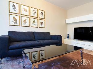 sala de estar con sofá azul y TV en Apartment Braila, en Plovdiv
