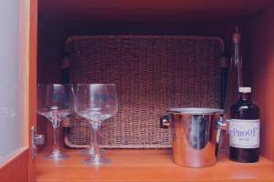 two glasses and a bottle of wine on a shelf at Apartamento Vista al Ara in Aínsa
