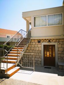 Un escalier mène à une maison avec une porte. dans l'établissement Laguna Apartment, à Mlini