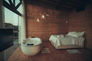 1 dormitorio con bañera y 1 cama en Cabanas nos Canyons, en Praia Grande