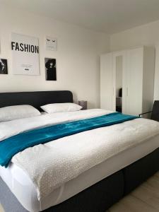 ein Schlafzimmer mit einem großen Bett mit einer blauen Decke in der Unterkunft Zentrales City Penthouse in Friedrichshafen