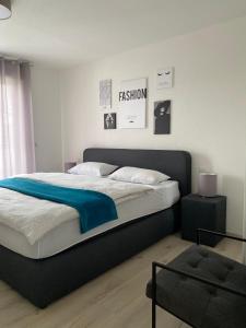 ein Schlafzimmer mit einem großen Bett mit einer blauen Decke in der Unterkunft Zentrales City Penthouse in Friedrichshafen