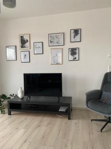 a living room with a flat screen tv and two chairs at Zentrales City Penthouse in Friedrichshafen