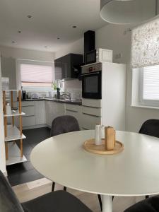 eine Küche mit einem weißen Tisch und einem weißen Kühlschrank in der Unterkunft Zentrales City Penthouse in Friedrichshafen