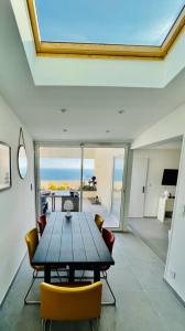 een eetkamer met een houten tafel en stoelen bij MAGNIFIQUE APPARTEMENT T4 GRAND STANDING - VUE MER PANORAMIQUE ET PISCINE in Bandol