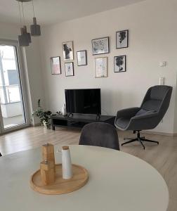 ein Wohnzimmer mit einem Tisch, 2 Stühlen und einem TV in der Unterkunft Zentrales City Penthouse in Friedrichshafen
