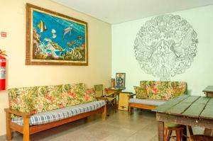 a living room with two couches and a painting on the wall at Verde Hostel Ilhabela in Ilhabela