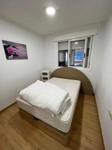a small bed in a room with a window at Alojamiento Pichi in Vigo