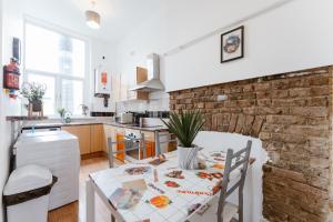 a kitchen with a table and a brick wall at Bethnal Green beds to stay in London