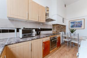 a kitchen with wooden cabinets and a counter top at Bethnal Green beds to stay in London +30 photos