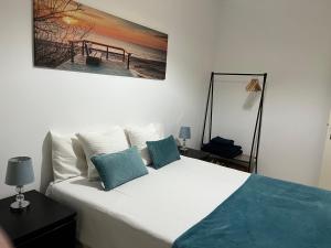 a bedroom with a bed with a painting on the wall at Confort Apartment 2 Bedrooms in Alhos Vedros