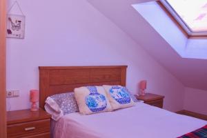 a bed with two pillows on it in a attic at Apartamento Vista al Ara in Aínsa