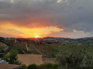 een zonsondergang boven een veld met zonsondergang bij La Voce della Natura in Fermo