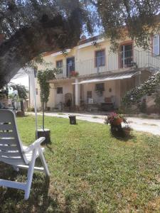 a white chair sitting in the yard of a house at La Voce della Natura in Fermo