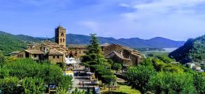 an old building with a clock tower in a village at Apartamento Vista al Ara in Aínsa