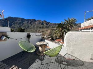 サンタ・ルシアにあるLa Casa de Tirajana free wifi 600 mbの山々を背景にテーブルと椅子2脚付きのパティオ