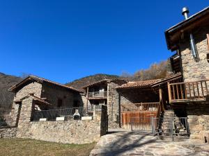 ein großes Steingebäude mit Veranda und Balkon in der Unterkunft Cal Lluch in Víllec