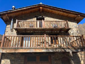 a wooden balcony on the side of a building at Cal Lluch in Víllec