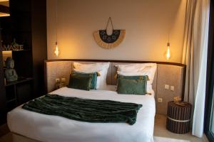 a bedroom with a bed with a green blanket on it at MW Douro Wine & Spa Experience Hotel Collection in Santa Marta de Penaguião