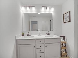 ein weißes Badezimmer mit Waschbecken und Spiegel in der Unterkunft Gorgeous New Townhome/Charlotte! in Charlotte + 20 Fotos