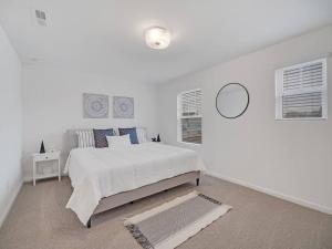 ein weißes Schlafzimmer mit einem Bett und einem Spiegel in der Unterkunft Gorgeous New Townhome/Charlotte! in Charlotte