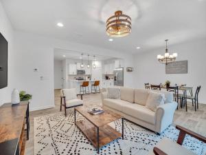 ein Wohnzimmer mit einer Couch und einem Tisch in der Unterkunft Gorgeous New Townhome/Charlotte! in Charlotte