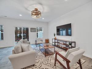 ein Wohnzimmer mit zwei Sofas und einem Fernseher in der Unterkunft Gorgeous New Townhome/Charlotte! in Charlotte