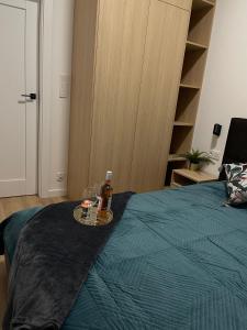 - un lit avec une bouteille de bière et une boisson dans l'établissement Golden Garden Apartment Tuwima Street, à Łódź
