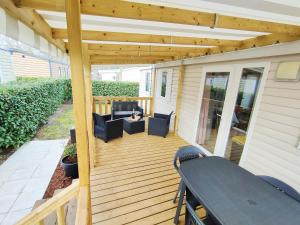 a wooden deck with chairs and a table at Vos MEILLEURS Vacances en Mobil Home in Gastes
