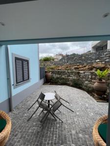 un patio con 2 sillas y una mesa en un patio en Quinta Vale Vitis en São Vicente