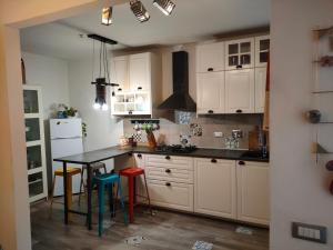 a kitchen with white cabinets and a table with colorful stools at La casa di Piera e Gina in Perugia