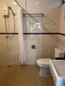 a bathroom with a shower and a toilet and a sink at Babylon Residence Inn pattaya in Pattaya South +40 photos