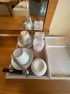 a tray with plates and spoons and a mirror at Babylon Residence Inn pattaya in Pattaya South