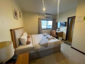 a bedroom with a bed with a window and a desk at Babylon Residence Inn pattaya in Pattaya South