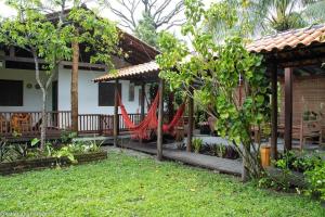 a house with a porch with a hammock in the yard at Casa aconchegante ampla e charmosa in Morro de São Paulo