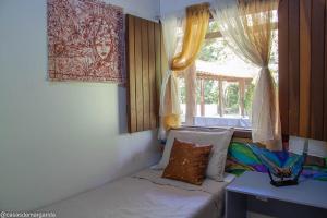 a room with a couch and a window at Casa aconchegante ampla e charmosa in Morro de São Paulo