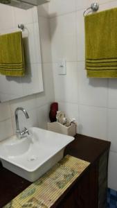 ein Badezimmer mit einem weißen Waschbecken und grünen Handtüchern in der Unterkunft Casa aconchegante ampla e charmosa in Morro de São Paulo