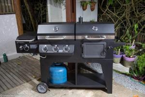 - un barbecue noir installé sur une terrasse agrémentée de plantes dans l'établissement Casa aconchegante ampla e charmosa, à Morro de São Paulo