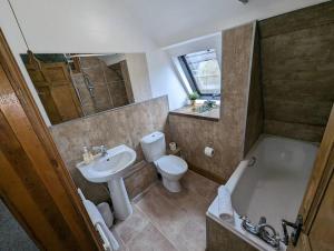 uma casa de banho com um lavatório, uma banheira e um WC. em River Street Rest em Bath