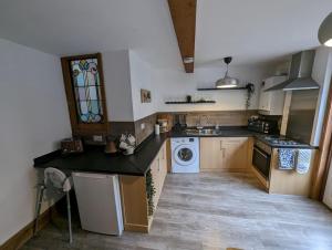 a kitchen with a sink and a washing machine at River Street Rest in Bath