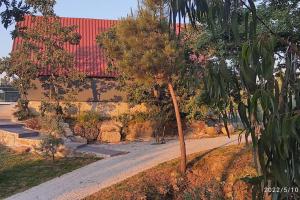 a building with a red roof next to a road at Casa do Neto. Anexo vale da Ginjeira. in Quinta da Carrapata