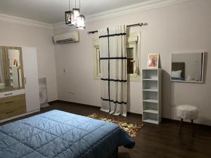 una camera con letto blu e specchio di Heliopolis Residence Shrouk city Cairo a Madīnat ash Shurūq