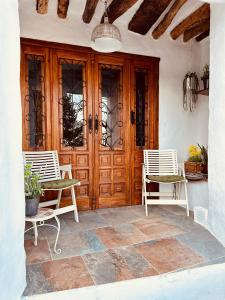 een veranda met 2 stoelen en een houten deur bij Casa Fabian in Polopos